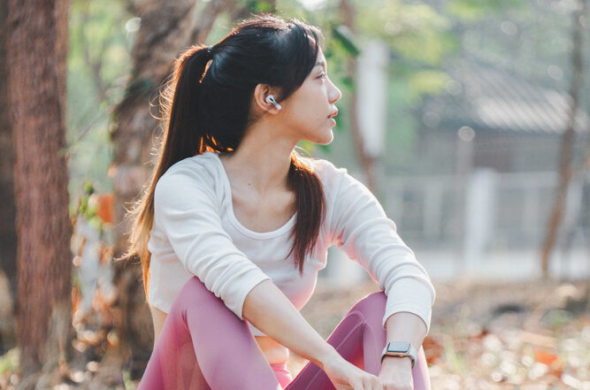 Asian woman with endometriosis sitting in park